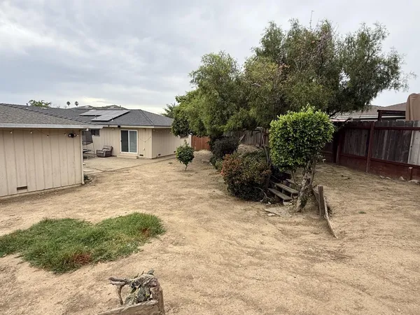 a backyard of a house with table and chairs
