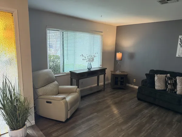 a living room with furniture and a wooden floor