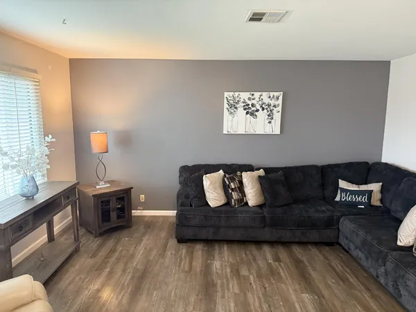 a living room with furniture and a wooden floor