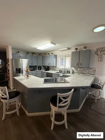 a kitchen with a sink and chairs