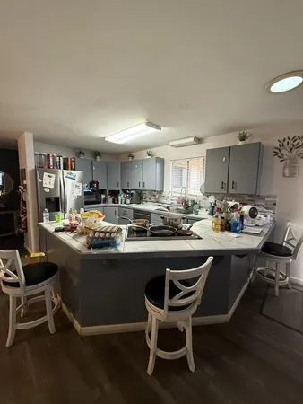 a kitchen with a sink and chairs