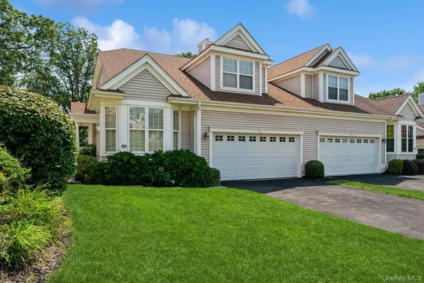 a view of a white house with a big yard and large trees