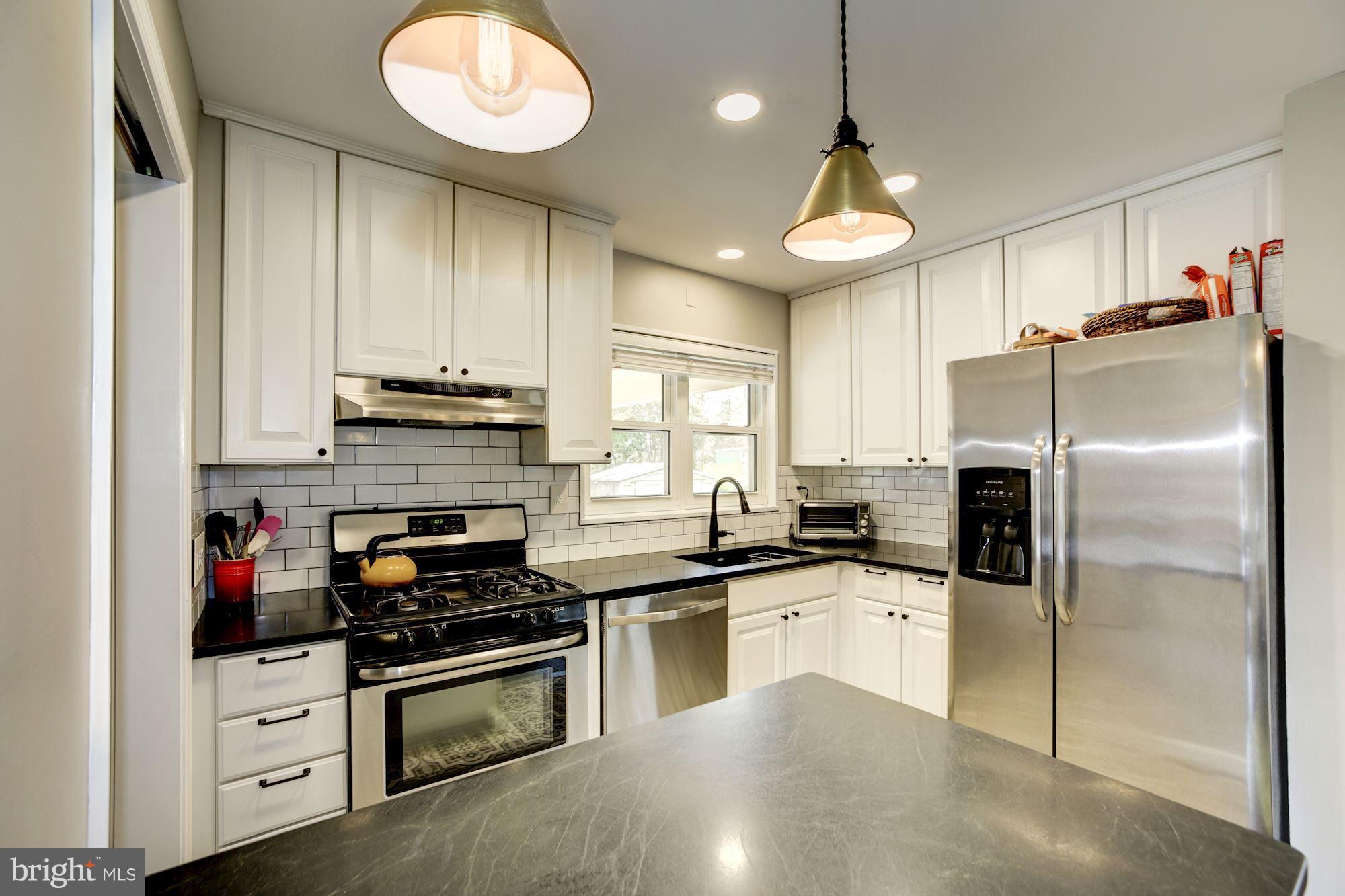 7414 Axton Street Springfield, VA 22151 - Photo 11 of 30 a kitchen with stainless steel appliances granite countertop a stove and a refrigerator