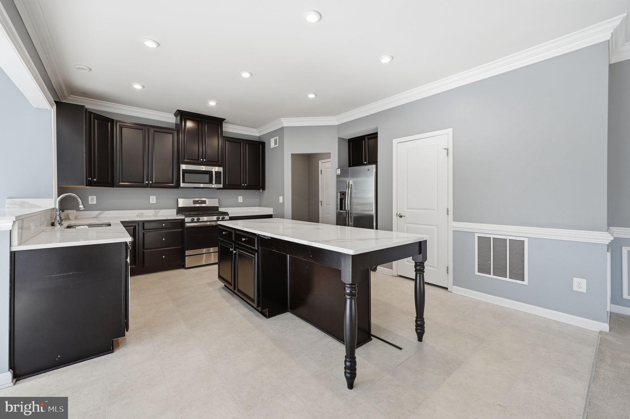 687 Blossom Tree Road Culpeper, VA 22701 - Photo 8 of 31 a kitchen with kitchen island a sink stainless steel appliances and cabinets