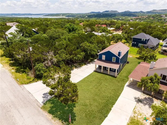 an aerial view of a house with a garden and lake view