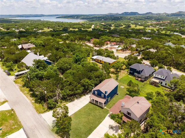 an aerial view of a house with swimming pool and yard