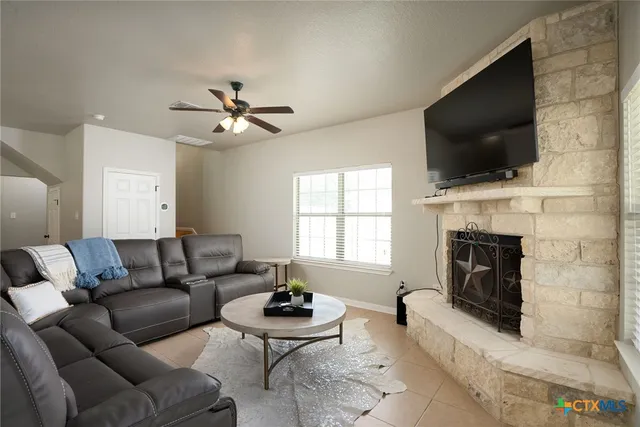 a living room with furniture a flat screen tv and a fireplace
