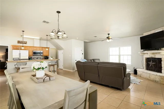 a living room with furniture a flat screen tv and a chandelier