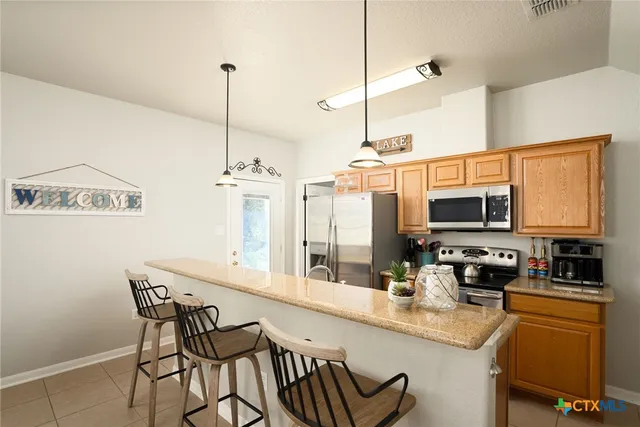 a kitchen with stainless steel appliances kitchen island granite countertop a sink and cabinets