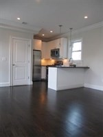 55 Middle Street, Unit 2 Boston, MA 02127 - Photo 5 of 5 a kitchen with granite countertop a stove top oven a sink a counter space and a window