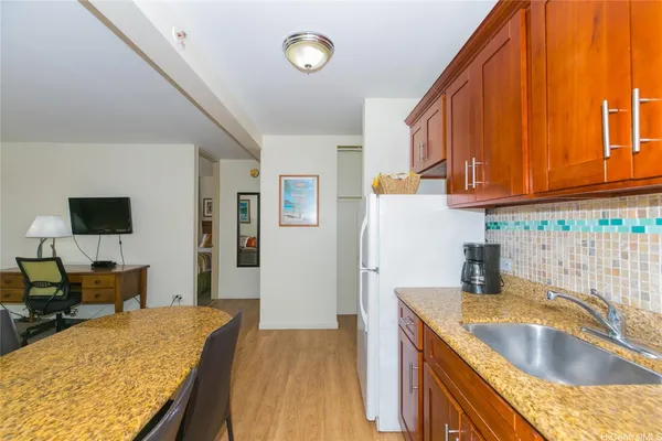 a kitchen with kitchen island granite countertop a sink a stove and a refrigerator