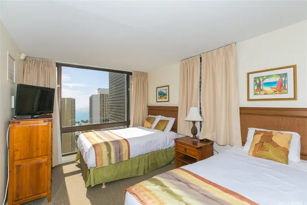 a bedroom with two beds and a flat screen tv