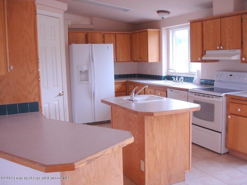 3360 County Road 233 Rifle, CO 81650 - Photo 9 of 33 a kitchen with kitchen island a sink a stove and a refrigerator