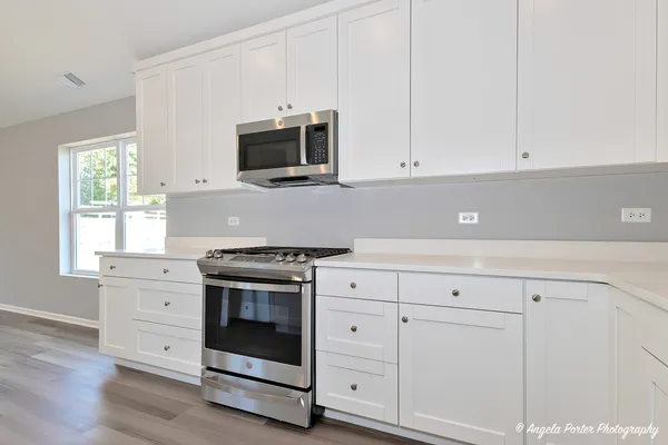 a kitchen with white cabinets and appliances
