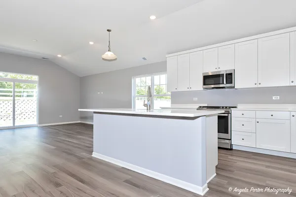a kitchen with granite countertop white cabinets and white appliances