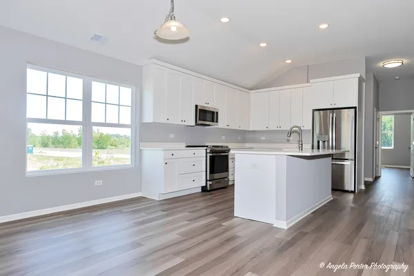 a kitchen with wooden floors and white cabinets