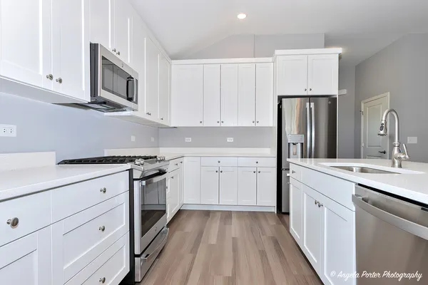 a kitchen with stainless steel appliances granite countertop a sink stove and refrigerator