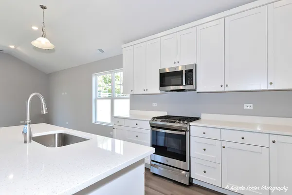 a kitchen with white cabinets and white appliances