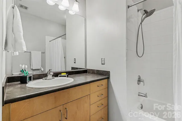 a bathroom with a granite countertop sink a shower and a mirror
