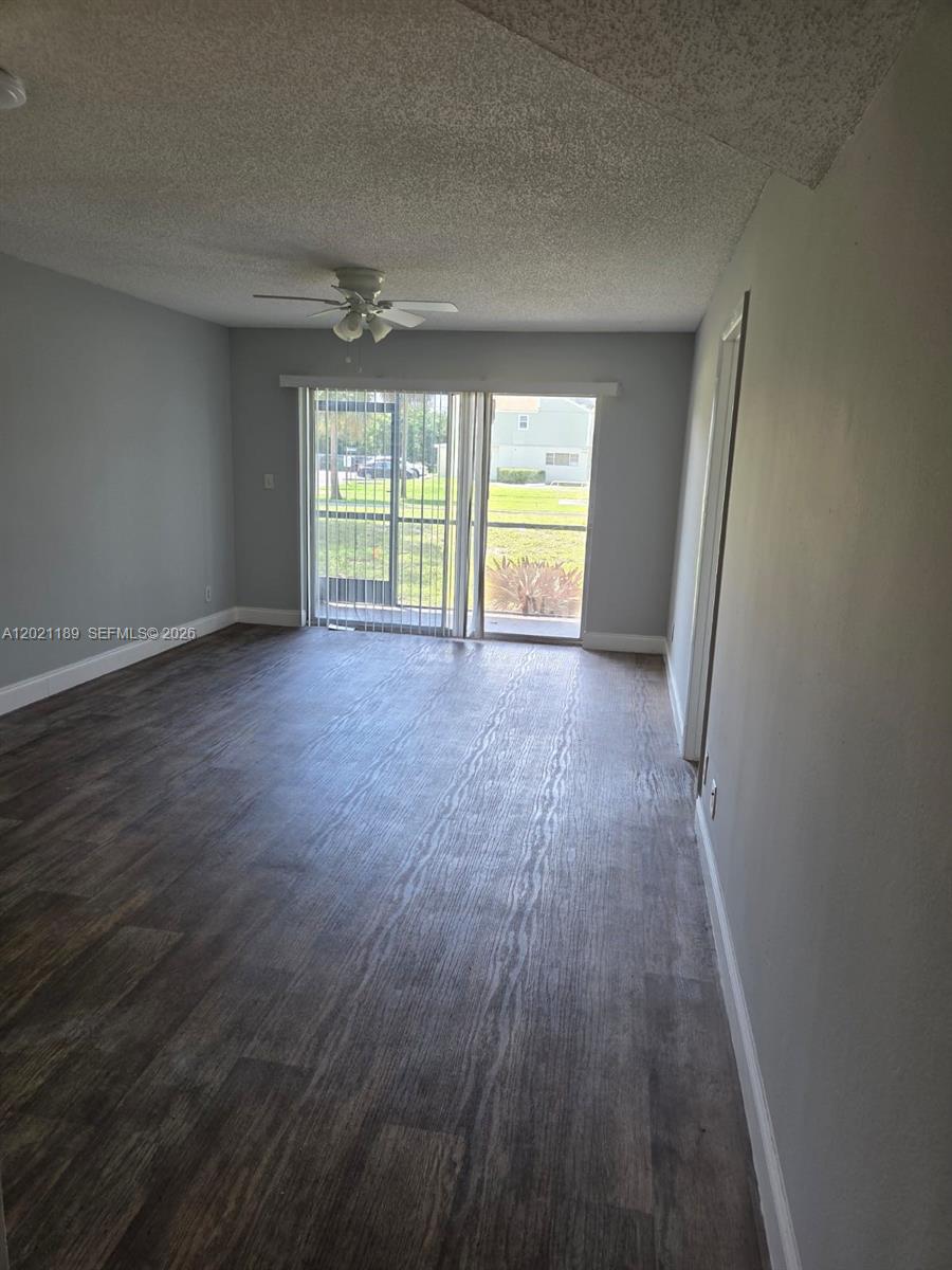 8060 North Colony Circle, Unit 103 Tamarac, FL 33321 - Photo 6 of 8 wooden floor in an empty room with a window