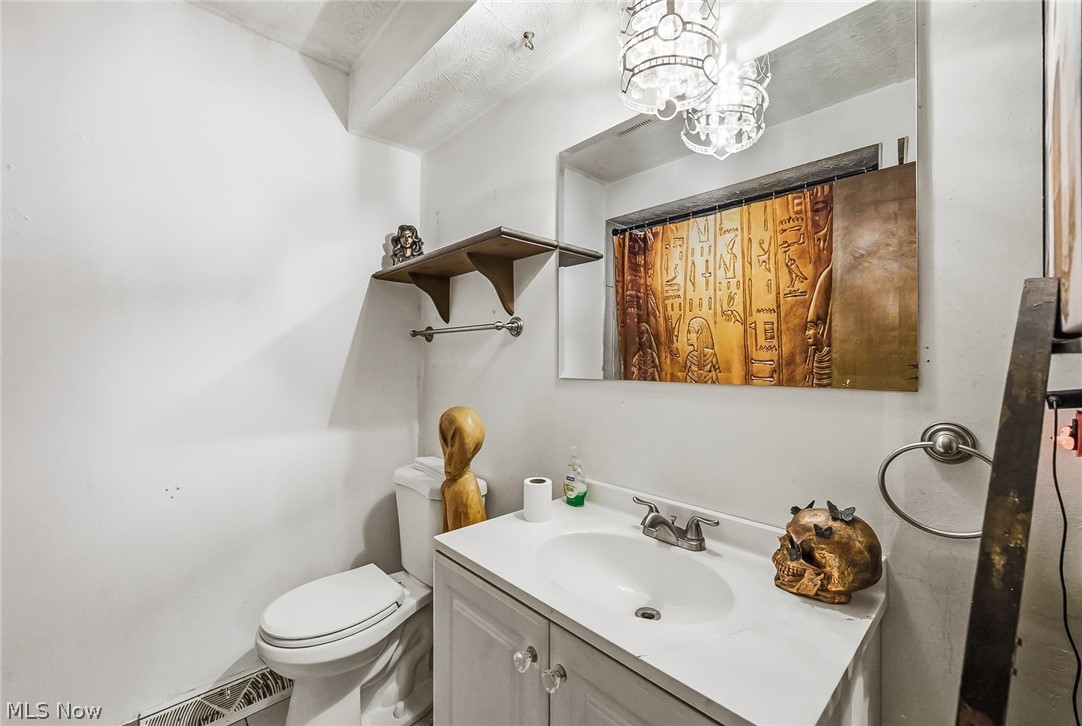 6890 Refugee Road Pickerington, OH 43147 - Photo 29 of 49 Bathroom featuring a vanity with a white countertop and integrated sink, chrome faucet, wall-mounted mirror, and decorative light fixtures