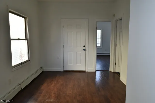 an empty room with wooden floor and a window