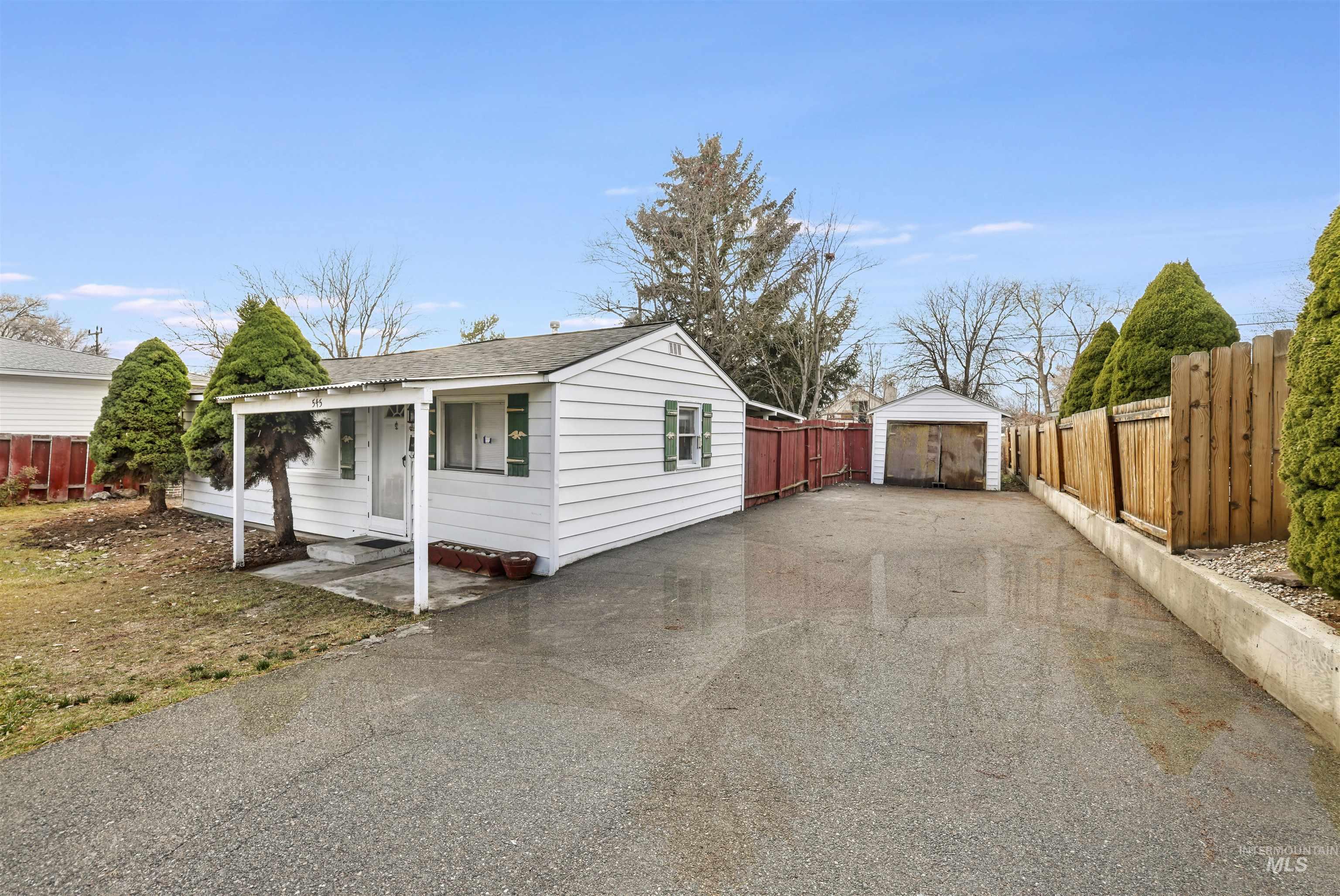 545 Madison Street Twin Falls, ID 83301 - Photo 2 of 23 View of property exterior featuring a shingled roof, driveway, an outdoor structure, and a detached garage