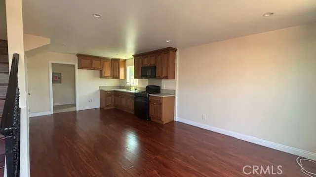 a kitchen with wooden floors and white stainless steel appliances
