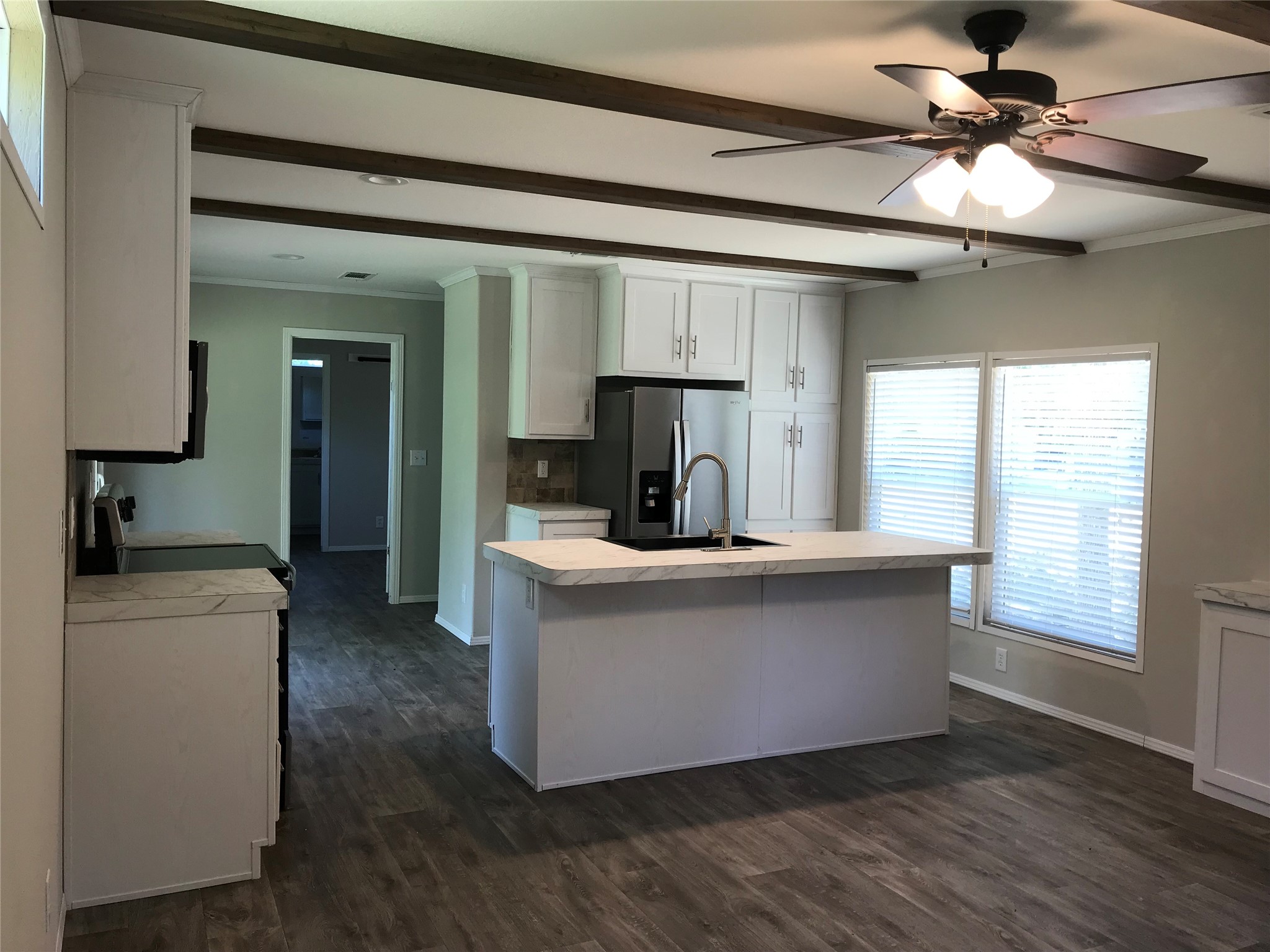 246 Brenda Road Trinity, TX 75862 - Photo 7 of 28 a living room with stainless steel appliances kitchen island a large window wooden floor and a refrigerator
