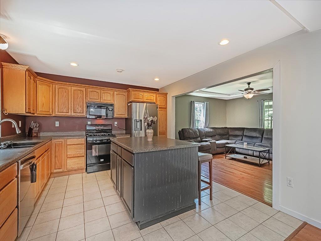 1928 Dime Road Vandergrift, PA 15690 - Photo 12 of 41 a kitchen with stainless steel appliances granite countertop a stove top oven a sink dishwasher and a refrigerator with wooden cabinets