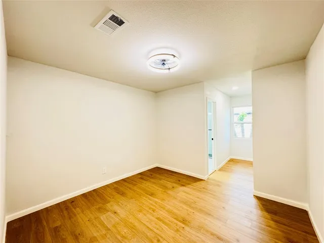 a view of a room with wooden floor and white walls