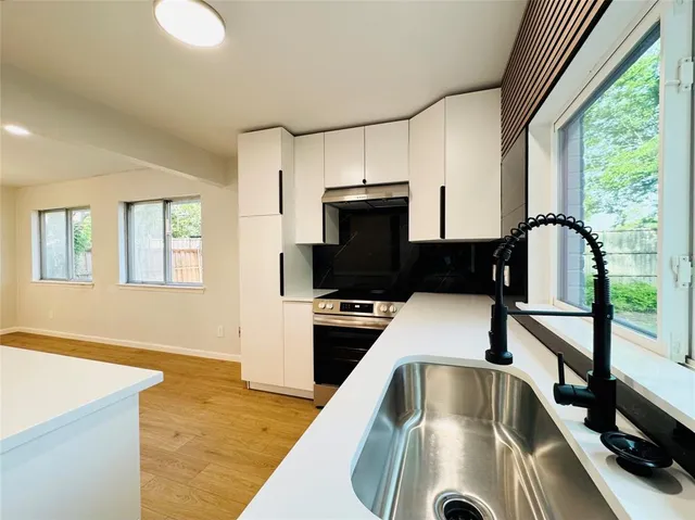 a kitchen that has a sink and a stove in it