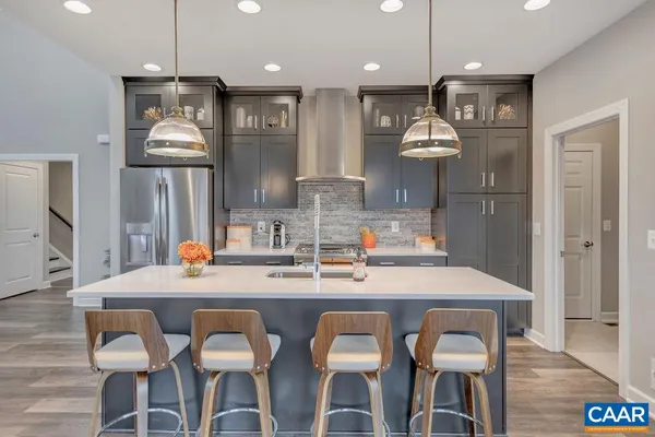 a kitchen with stainless steel appliances kitchen island granite countertop a kitchen island and chairs in it