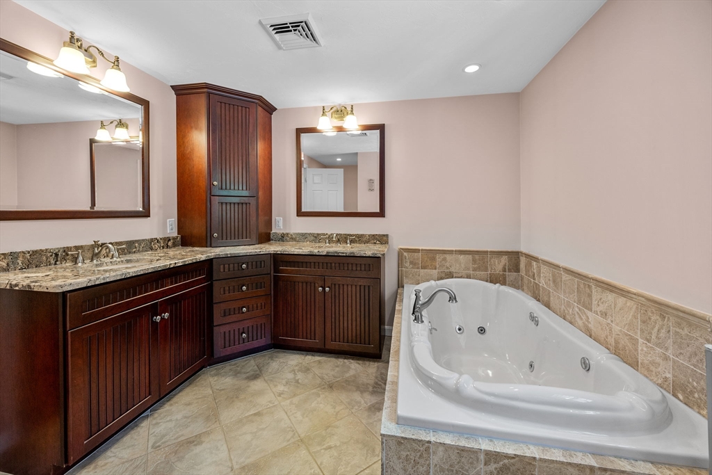 19 King Philip Path Mendon, MA 01756 - Photo 30 of 42 a spacious bathroom with a granite countertop tub sink and mirror