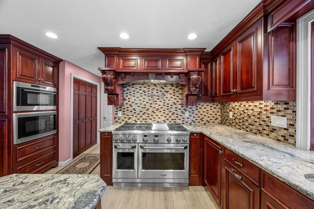 19 King Philip Path Mendon, MA 01756 - Photo 8 of 42 a kitchen with stainless steel appliances granite countertop wooden cabinets and a stove top oven