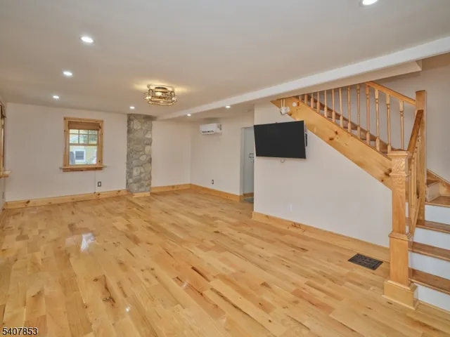 a view of a bedroom with wooden floor and windows