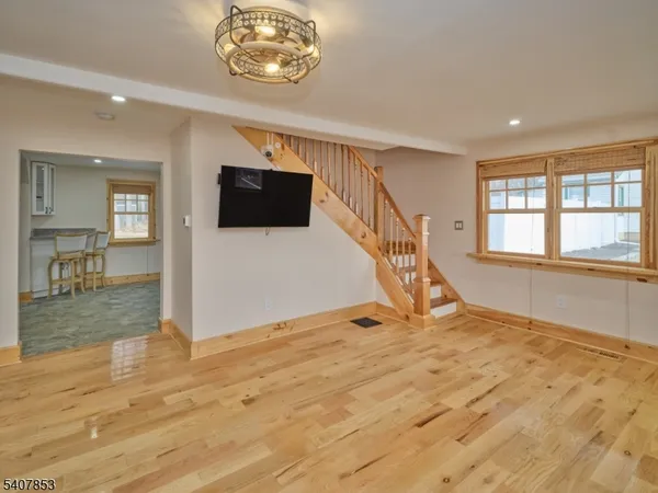 a view of a livingroom with wooden floor and a flat screen tv