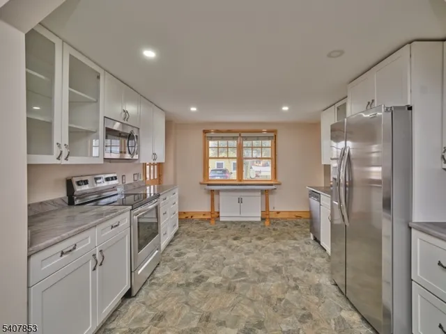 a kitchen with stainless steel appliances granite countertop a refrigerator and a stove top oven