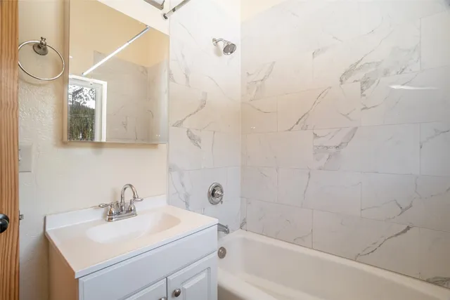 a bathroom with a sink mirror toilet and bathtub