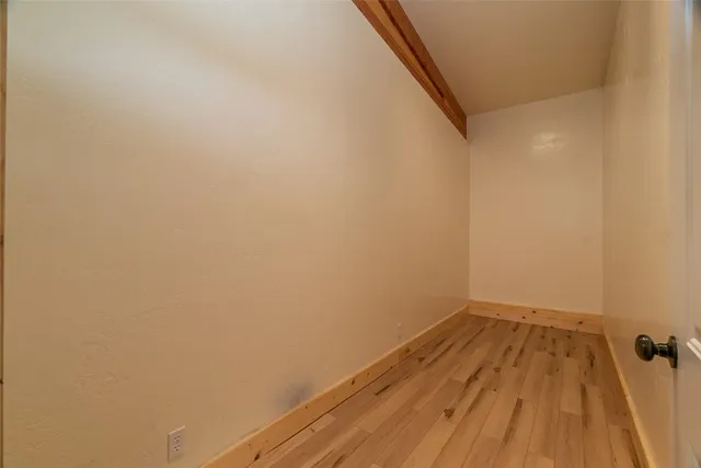 a view of a room with wooden floor and a ceiling fan