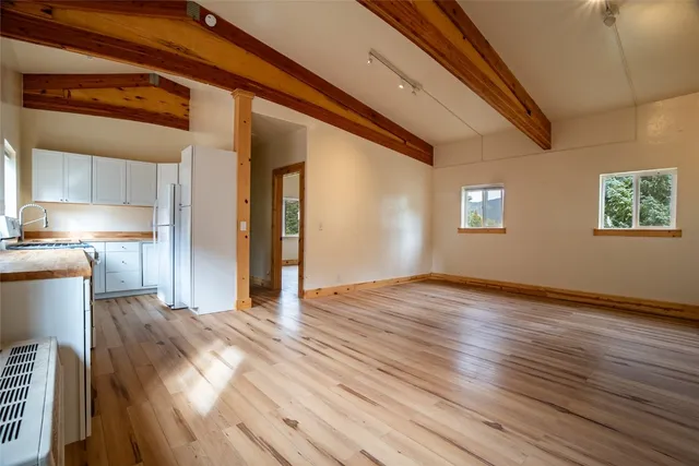 a view of empty room with wooden floor