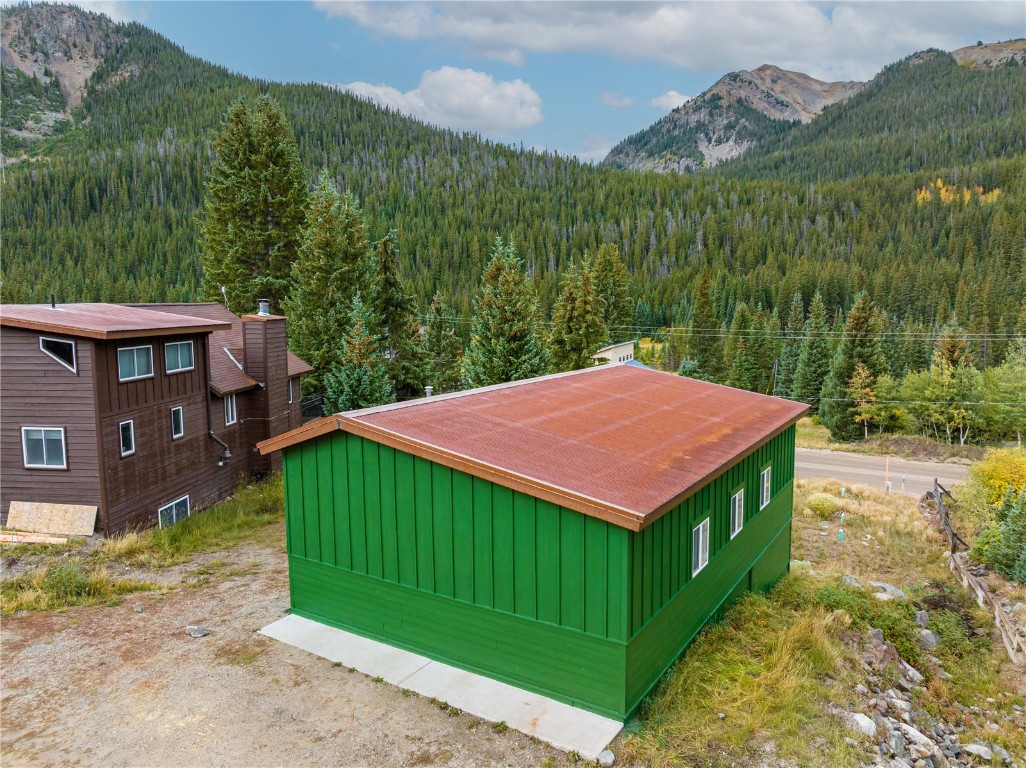 5277 Montezuma Road Montezuma, CO 80435 - Photo 25 of 30 a view of a barn with a yard plants and large trees