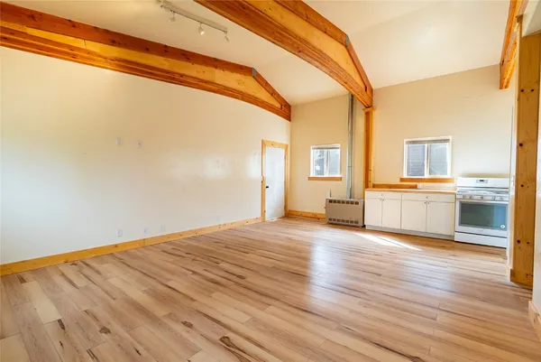 a view of a kitchen with wooden floor and windows