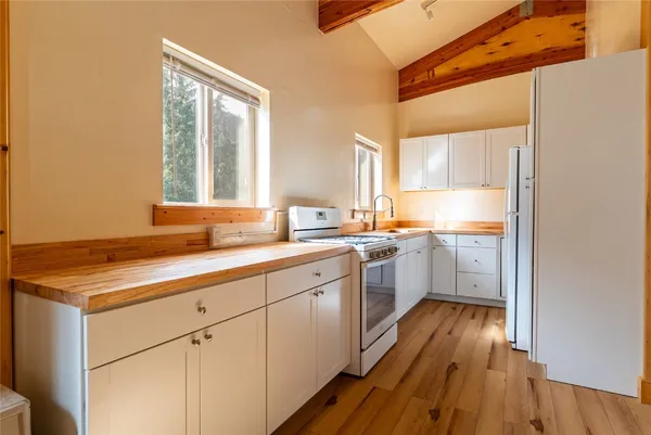a kitchen with wooden floors and white appliances