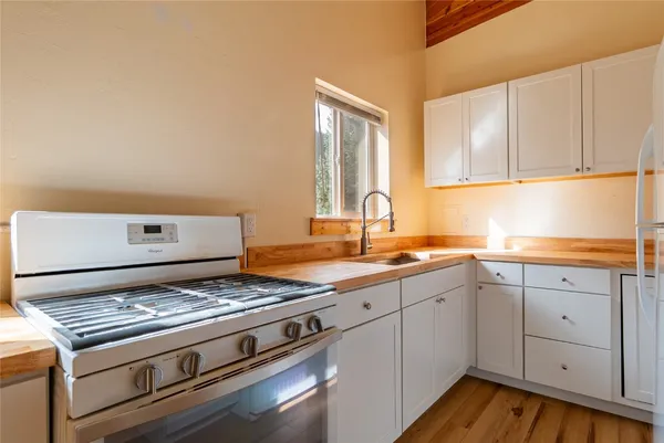 a kitchen with a stove and white cabinets