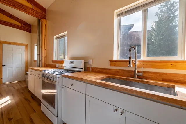 a kitchen with stainless steel appliances granite countertop a sink and a stove