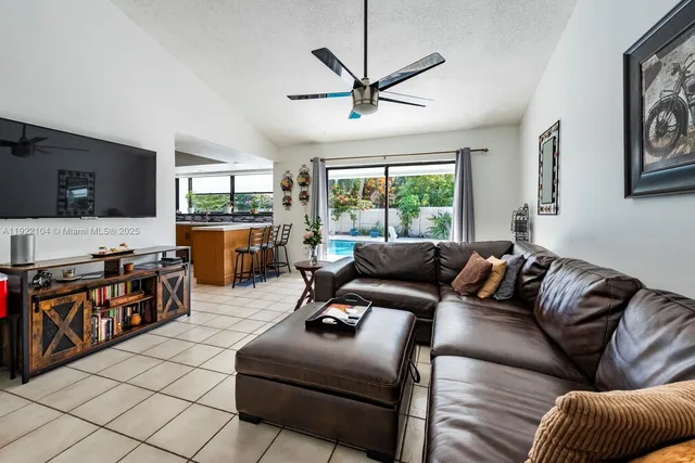 a living room with furniture ceiling fan and a window