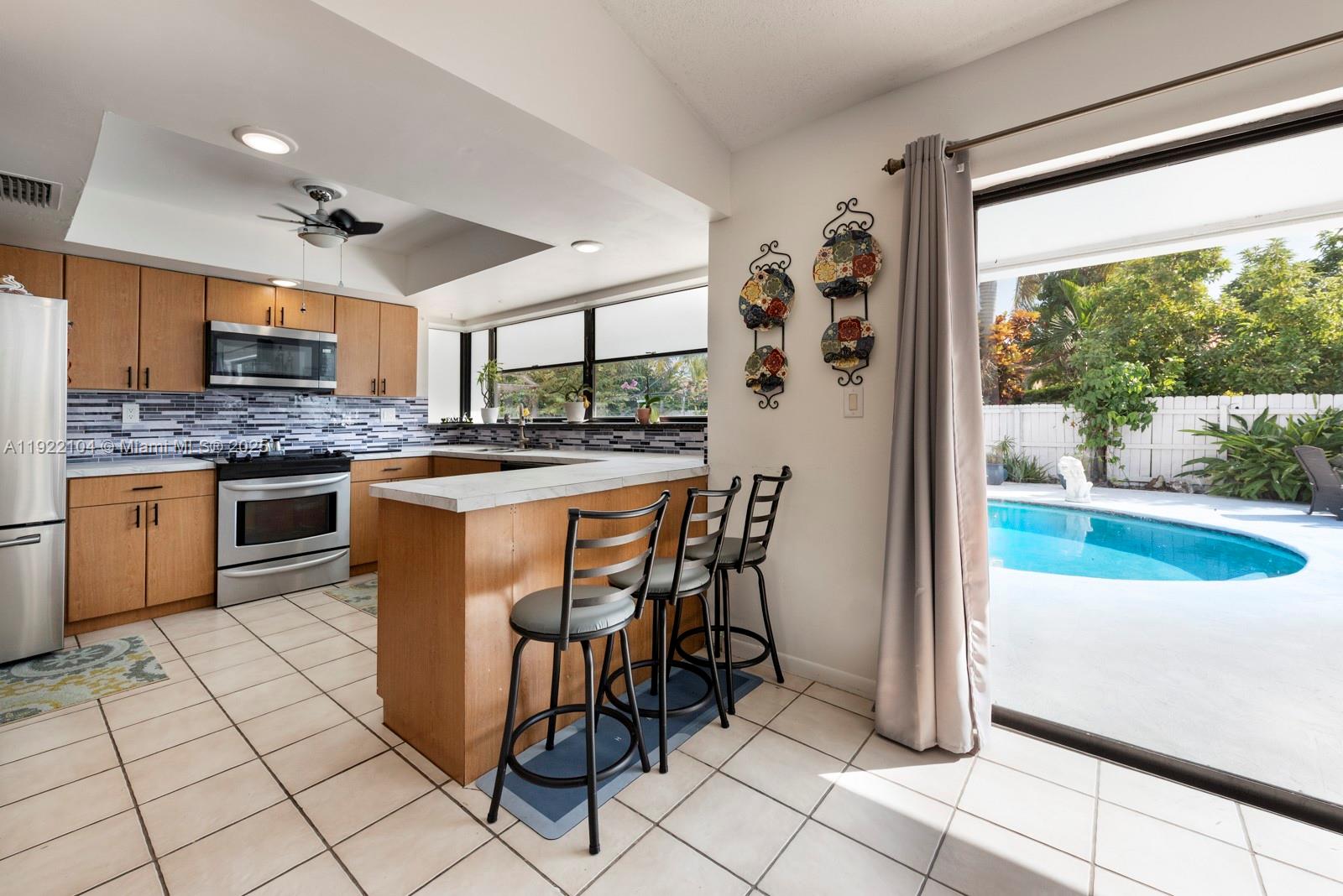 11724 Southwest 95th Street Miami, FL 33186 - Photo 13 of 25 a kitchen with stainless steel appliances granite countertop a stove a sink and a refrigerator