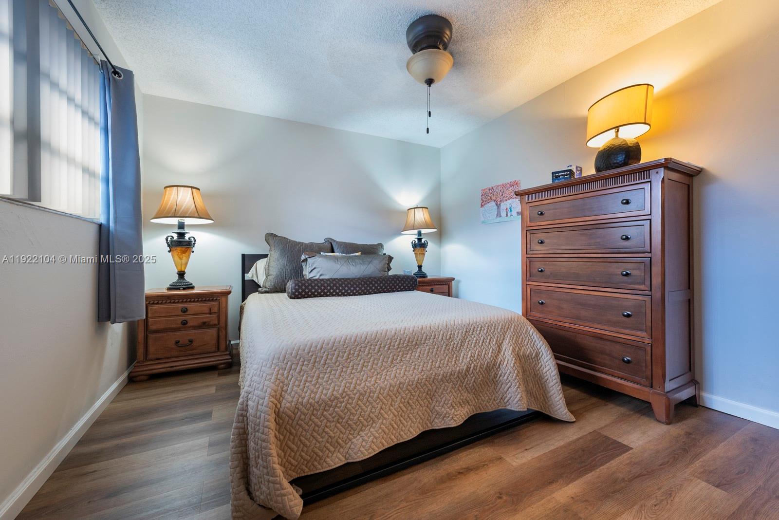 11724 Southwest 95th Street Miami, FL 33186 - Photo 17 of 25 a bedroom with a bed and a chandelier