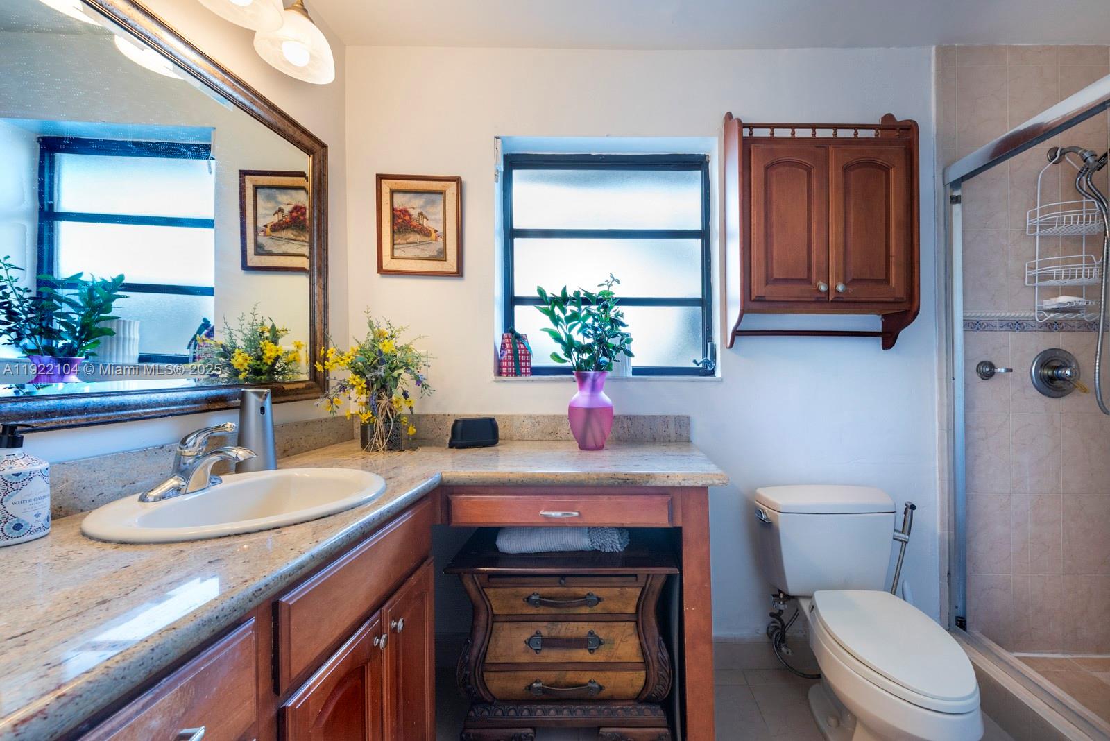 11724 Southwest 95th Street Miami, FL 33186 - Photo 18 of 25 a bathroom with a sink a toilet and mirror